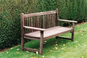 Traditional wooden bench with yew hedge