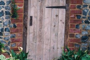 Wooden door in brick and flint wall